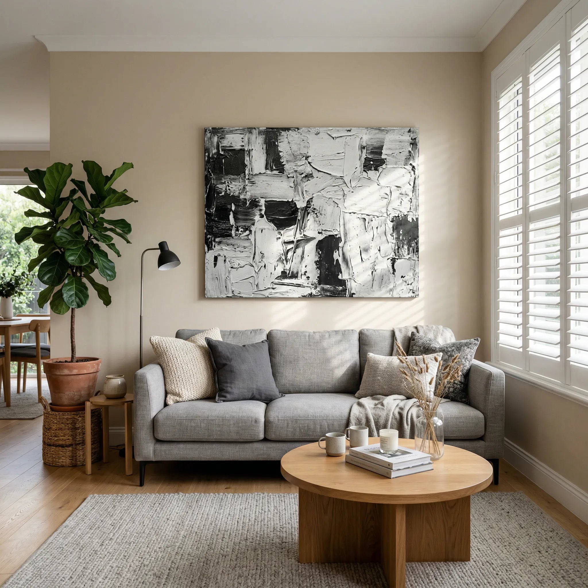 Black and White Textured Abstract Oil Painting hanging above a modern grey sofa in a bright living room by Inkich.